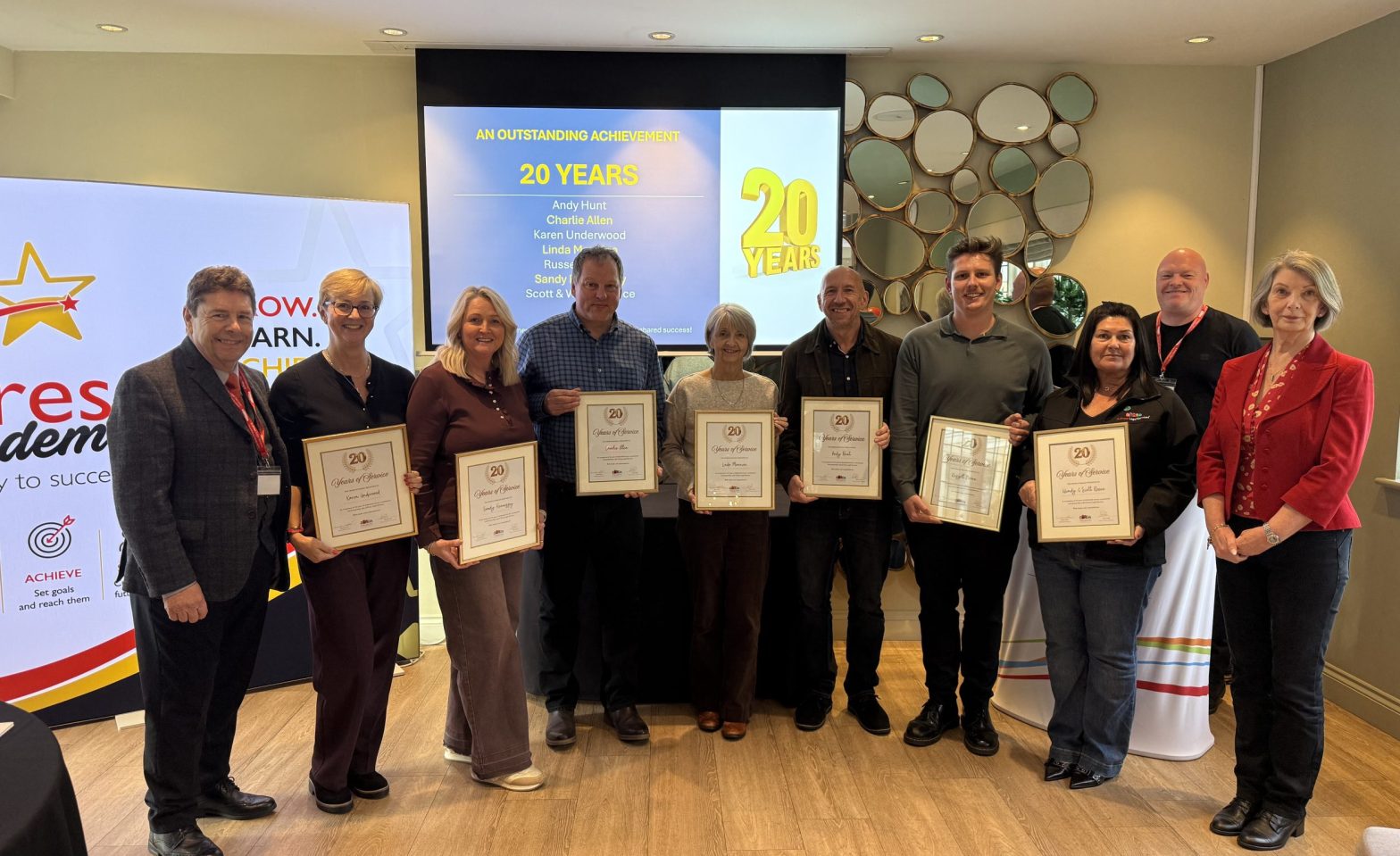 X-Press Legal Services franchisees proudly display their 20-year service awards, joined by company founders Dave and Lynne Lister (far left and right)